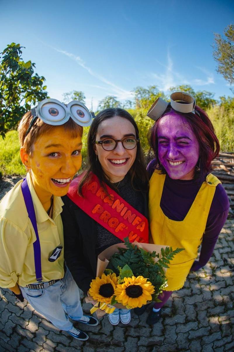 Trio fantasiado de minions com girassóis no trote